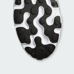 View of the outsole of the Nike Air Max 270 React Women's white trainers, showing the durable rubber tread pattern with flex grooves.