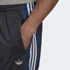 Adidas Men's BX-20 Graphic Sweat Pants shows the zipped pocket in use with the patterns in the material .