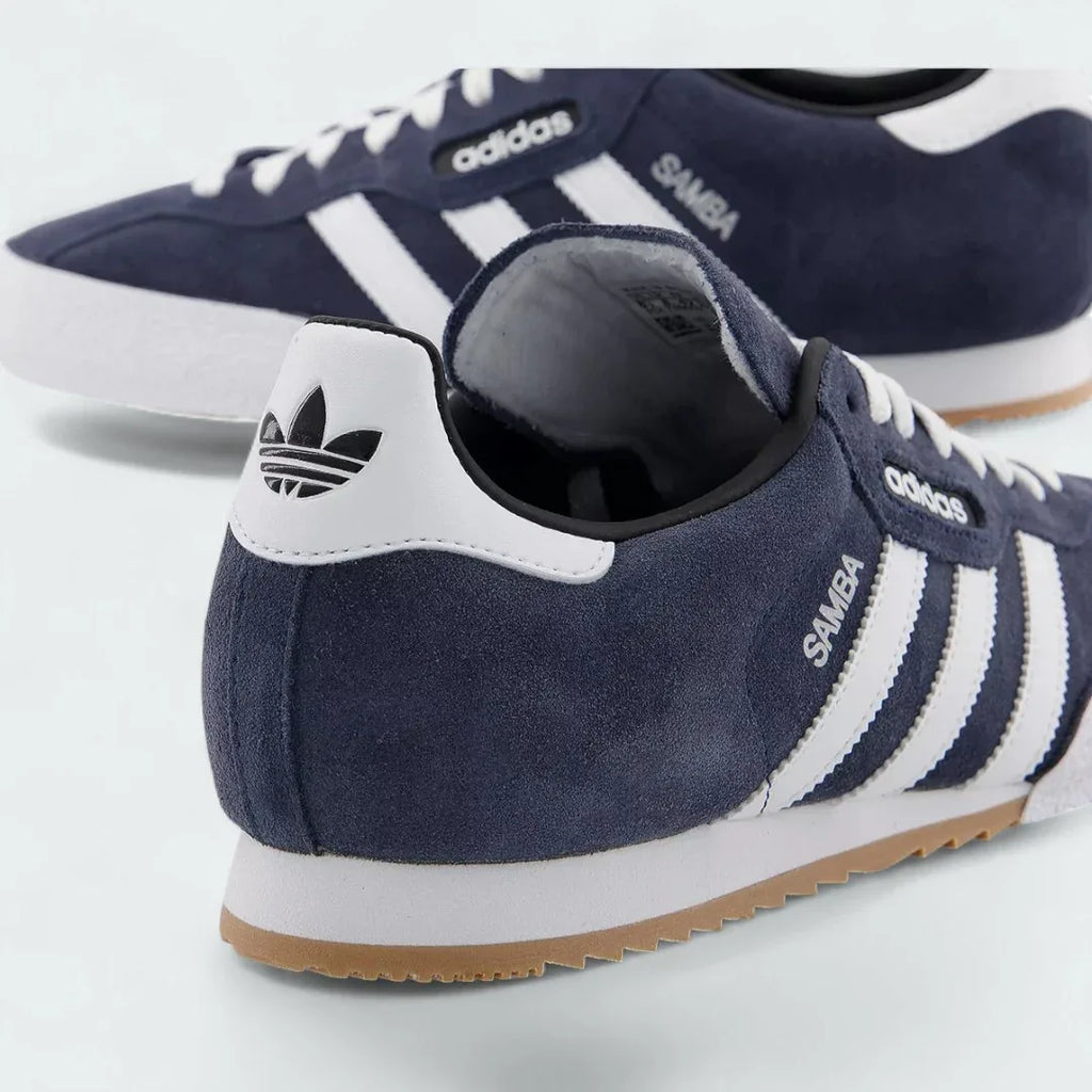 Detailed zoom on the side of the Adidas Samba Super Men's trainers, highlighting the "Samba" text next to the white 3-Stripes and the texture of the gum midsole.