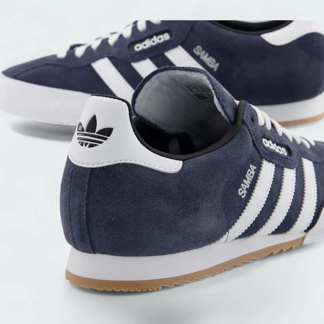 Detailed zoom on the side of the Adidas Samba Super Men's trainers, highlighting the "Samba" text next to the white 3-Stripes and the texture of the gum midsole.