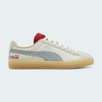 Puma Suede x Coca-Cola Unisex trainers in white suede with a red Formstrip, side profile showing the classic silhouette and a Coca-Cola branded heel tab.