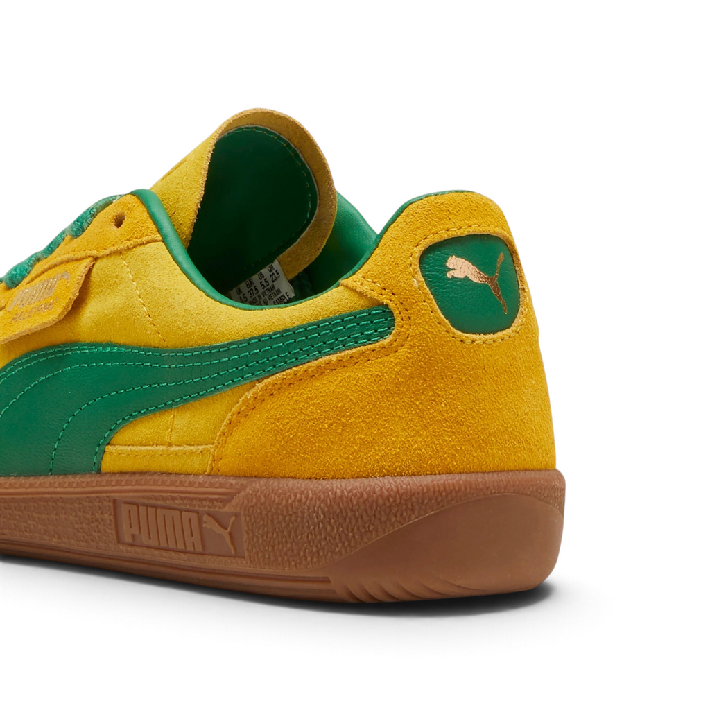 Focuses on the contoured shape of the green leather heel tab, showing the clean, screen-printed PUMA cat logo sitting above the texturized gum sole spine.