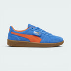 Highlights the high-velocity sweep of the flame orange leather Formstrip, showing the professional, rich sheen of the Hyperlink Blue suede upper and the shining gold foil Palermo branding flap.