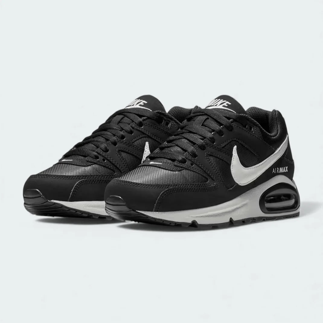 Angled view of two Nike Air Max Command Women's black trainers, side by side, showcasing their classic aesthetic and cushioned design.