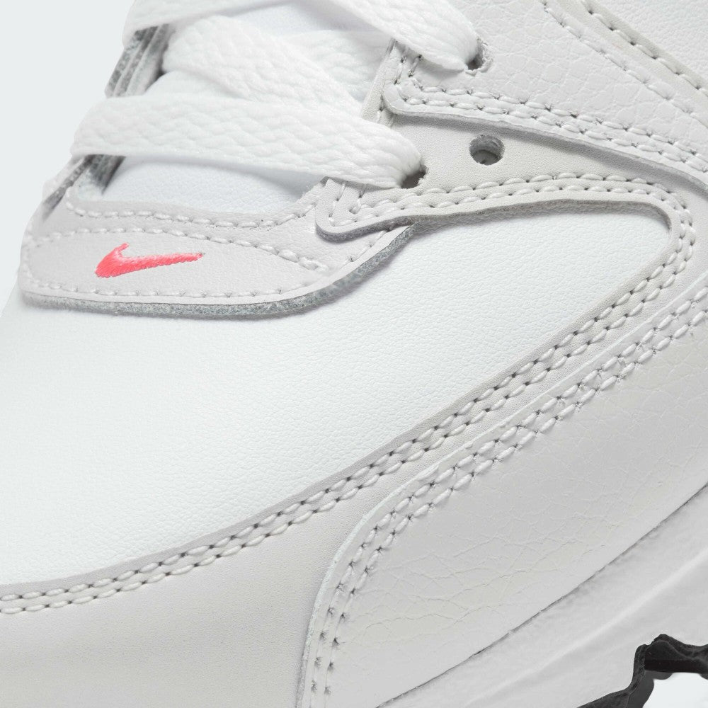 Close-up of a white leather Nike shoe showing the side panel, white laces, contrast stitching, and a small pink Nike swoosh logo.