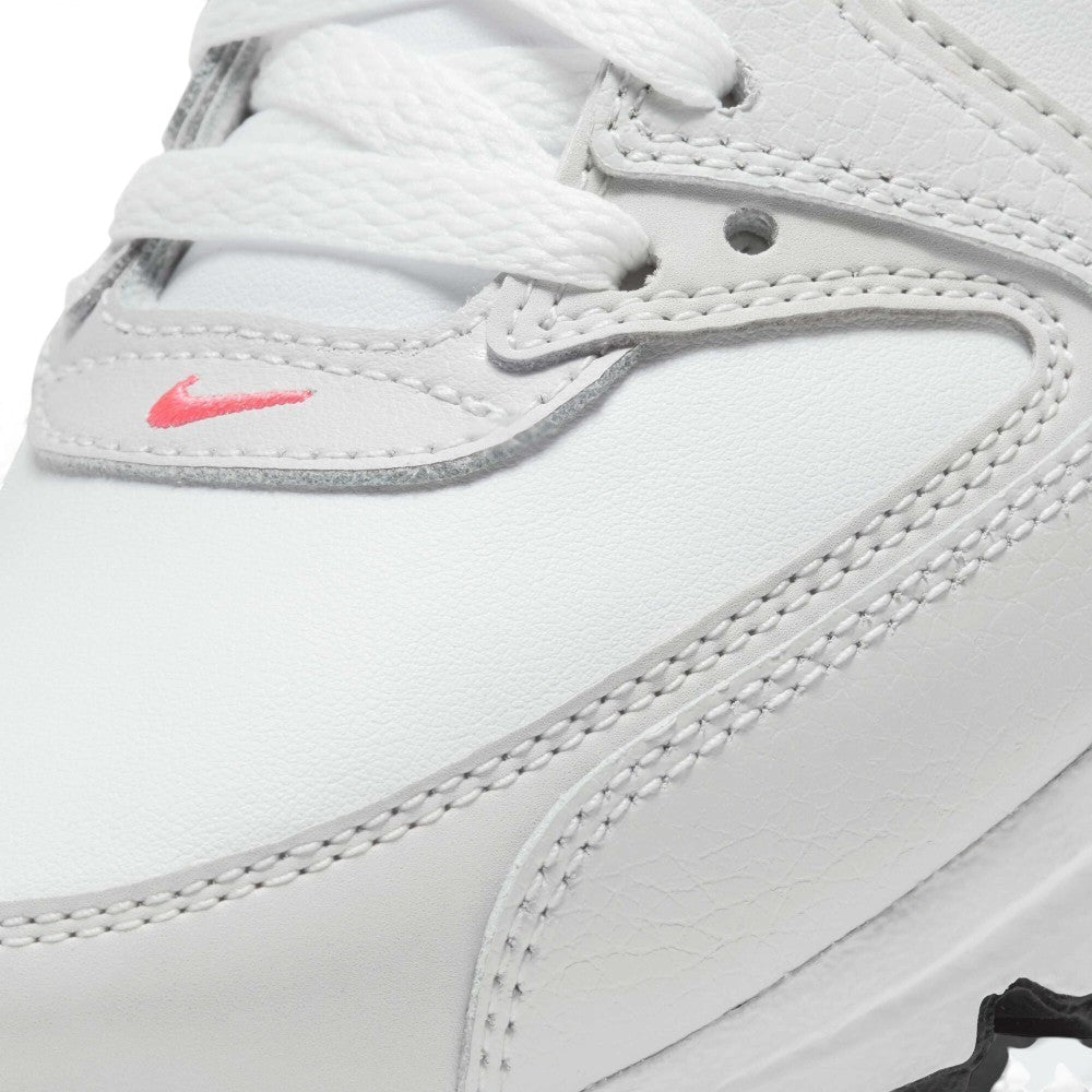 Close-up of a white leather Nike shoe showing the side panel, white laces, contrast stitching, and a small pink Nike swoosh logo.