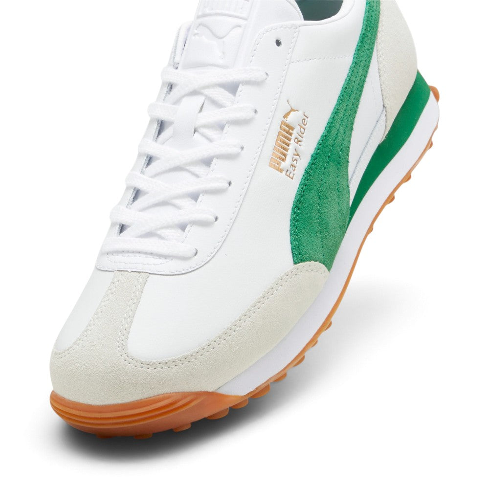 Highlights the forefoot and midfoot details from an angled three-quarter perspective, showcasing the textured off-white suede T-toe wrap, white leather vamp, flat laces through punched eyestays, embossed leather tongue crest, metallic gold foil "PUMA Easy Rider" branding, and lush green suede Formstrip.