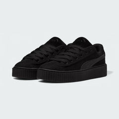 Angled view of two Puma Creeper Phatty x Fenty Women's trainers in black, side by side, showcasing their exaggerated platform and corduroy upper.