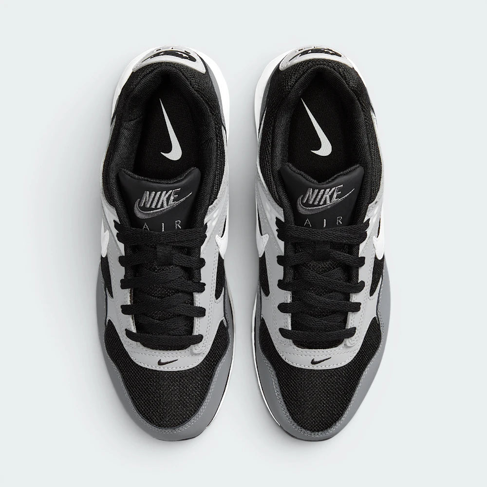 Focuses on the locked-in lace closure layout, the technical black mesh on the toe box, and the classic branded tongue patches.