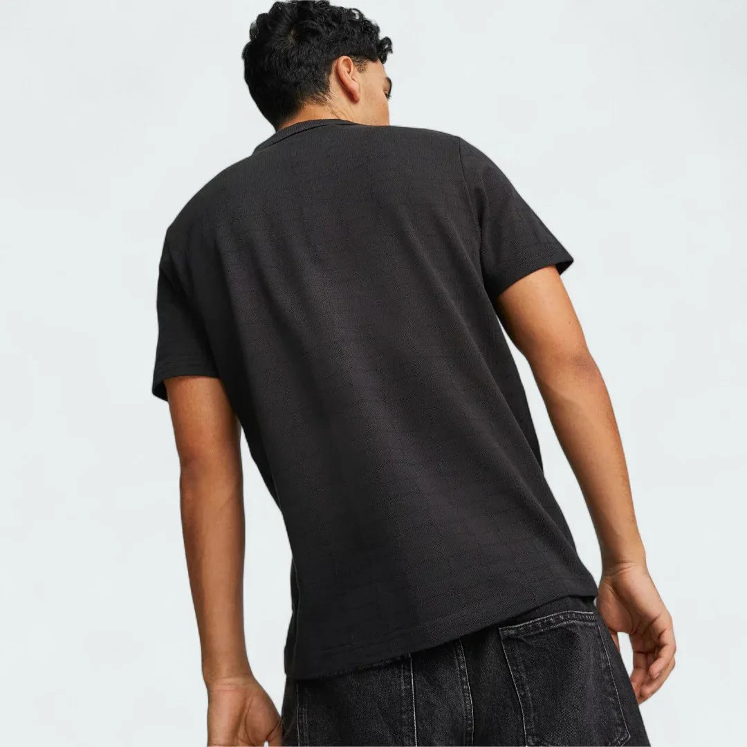 Puma Ferrari Style Jacquard Polo Men's in black, rear model image showing short sleeves, classic fit, and subtle jacquard texture.