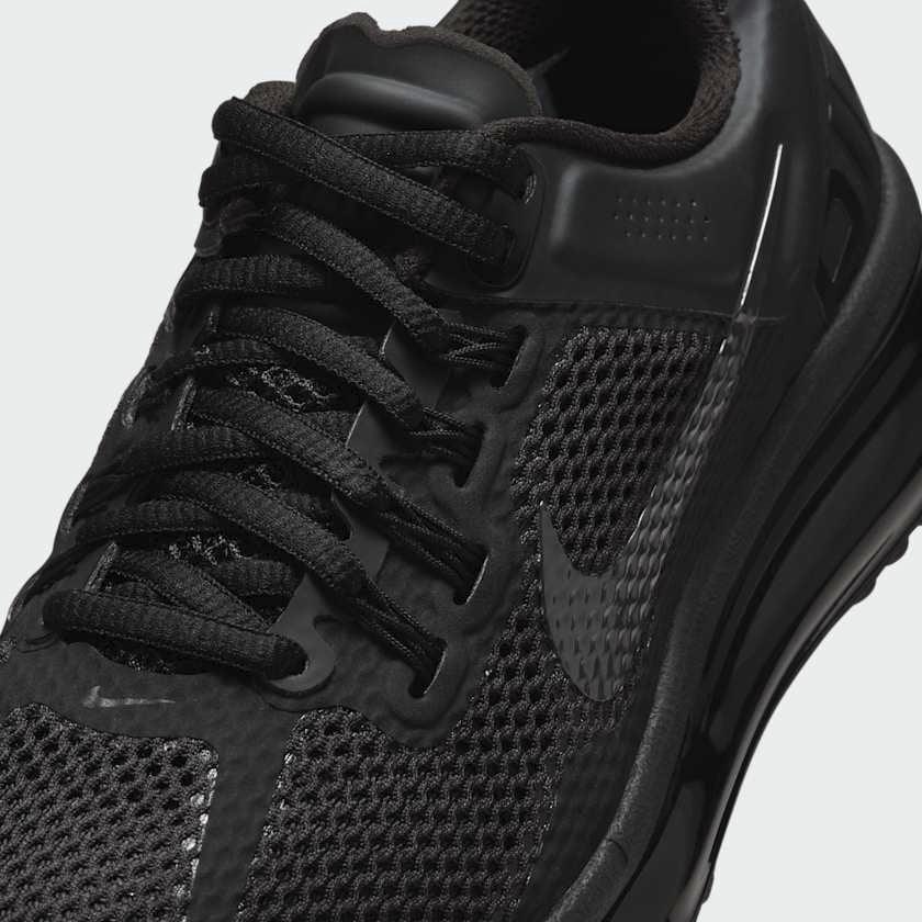 Close-up zoom on the front of the Nike Air Max 2013 Juniors' black trainers, showing the mesh upper texture, Flywire details, and lacing system.