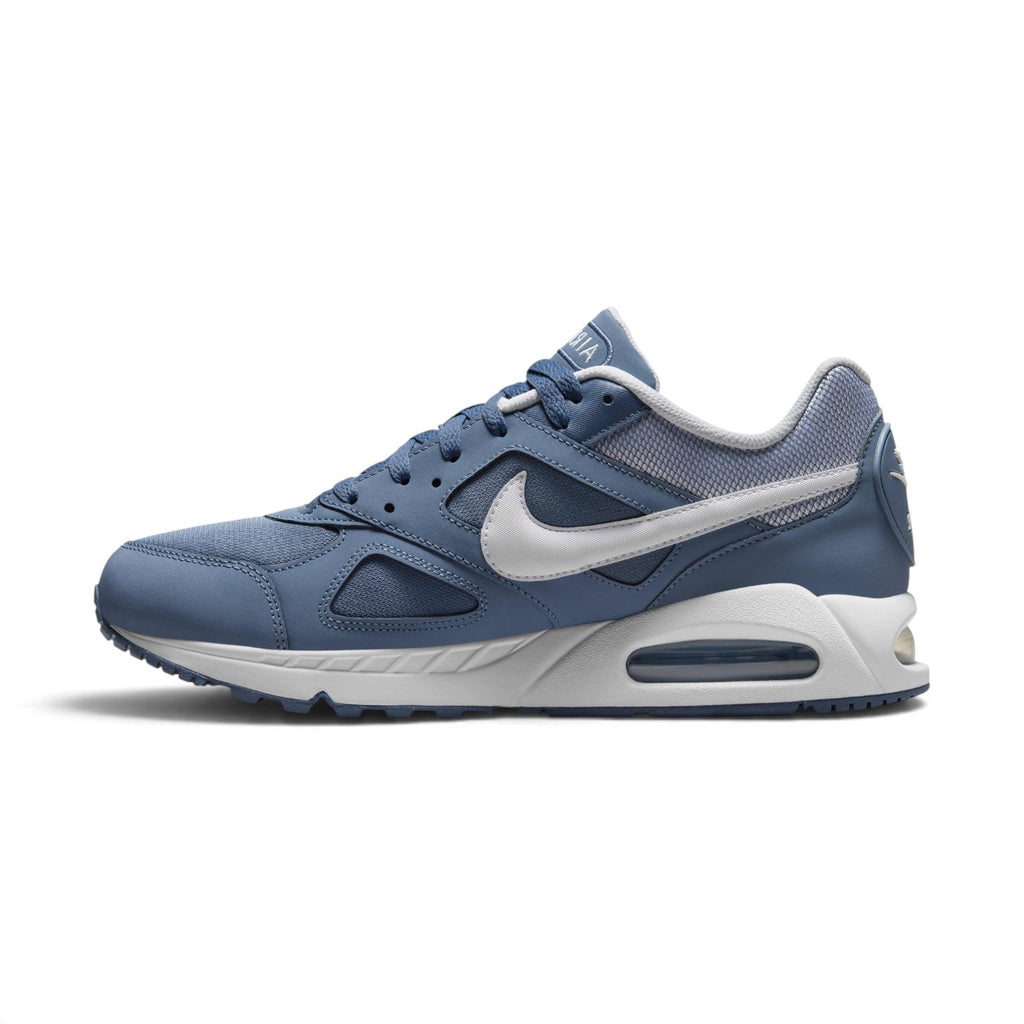 A Nike Air Max sneaker in a muted slate blue colorway, featuring a white Swoosh and a white midsole with a visible air cushion unit.