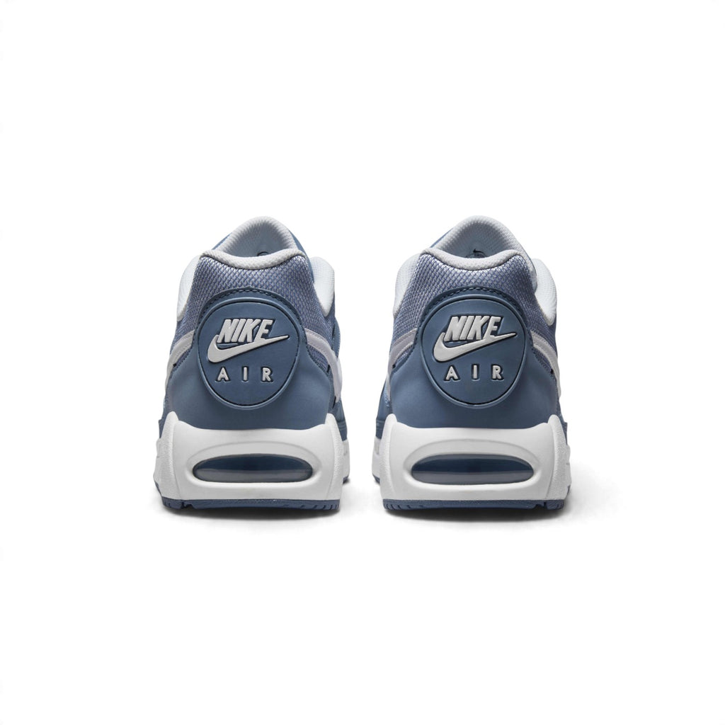 Rear view of the sneakers emphasizing the circular heel badges featuring Nike Air branding, white midsoles, and visible Air-Sole windows.