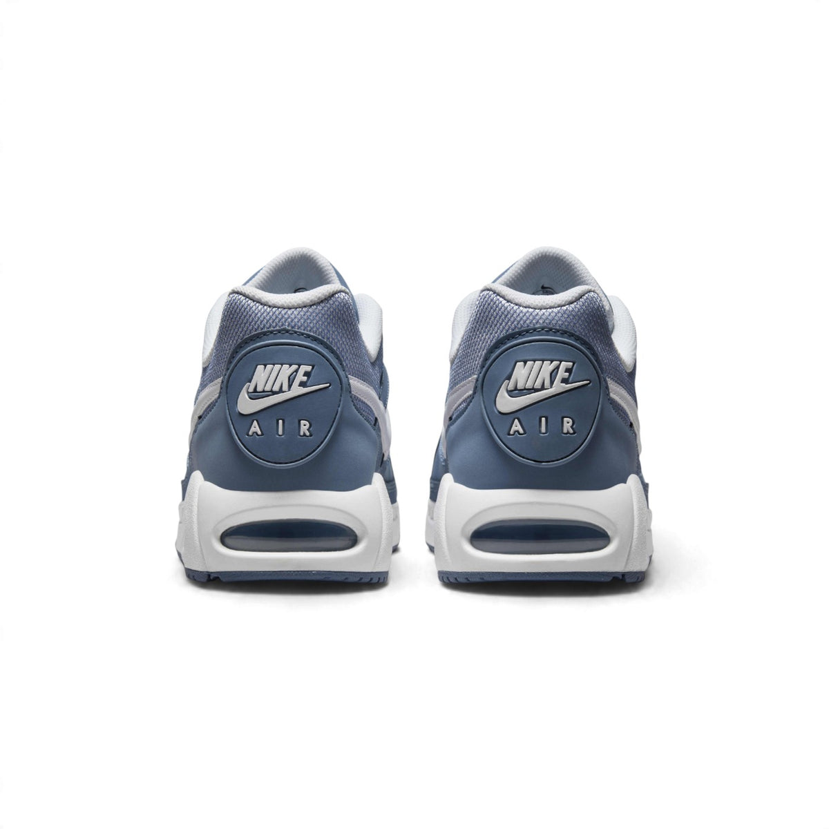 Rear view of the sneakers emphasizing the circular heel badges featuring Nike Air branding, white midsoles, and visible Air-Sole windows.