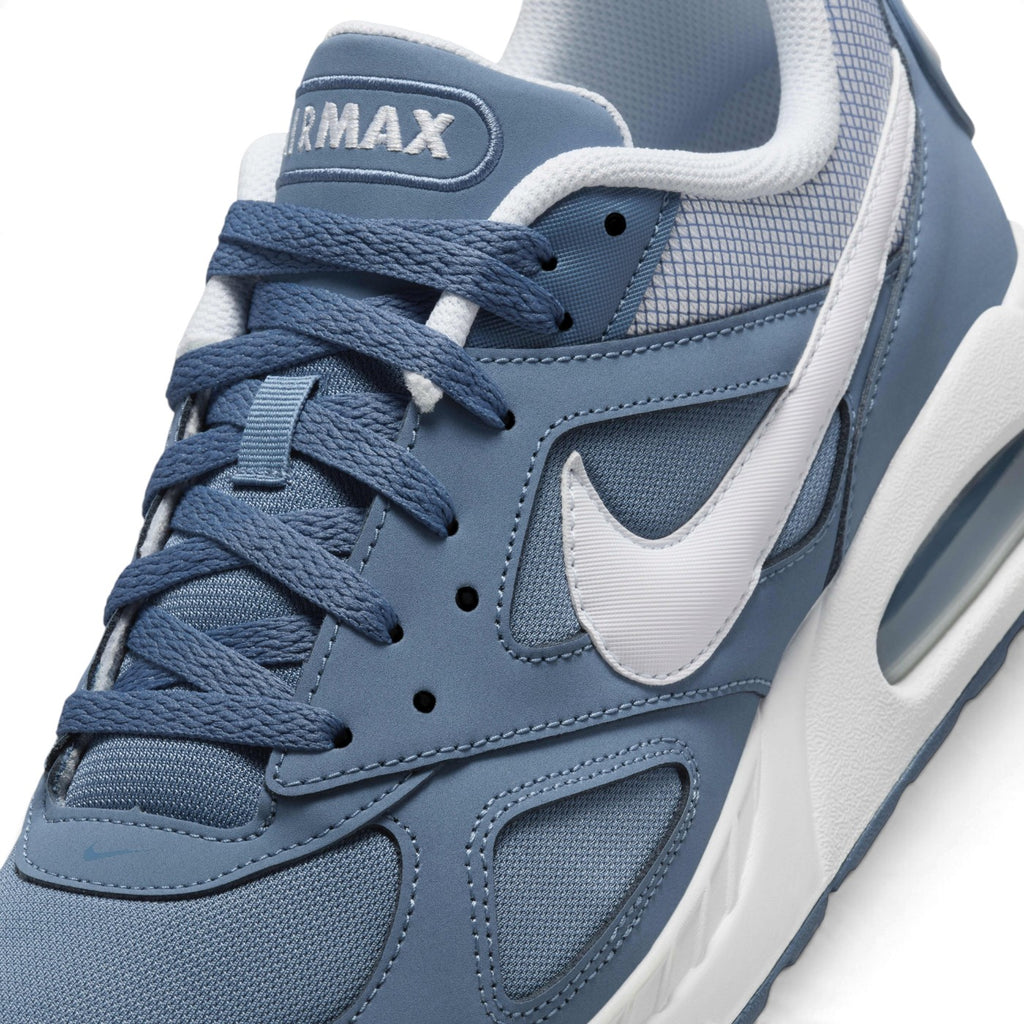 Macro focus on the forefoot and eyestay, detailing the airy mesh toe box, embroidered AIRMAX tongue label, and white side Swoosh.