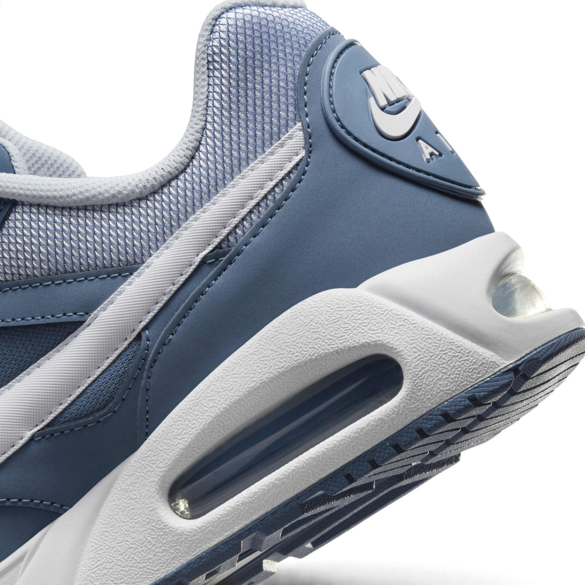 Macro view of the lateral heel transition, highlighting the sculpted white foam midsole, multi-angle Air-Sole window, and Waffle tread grip.