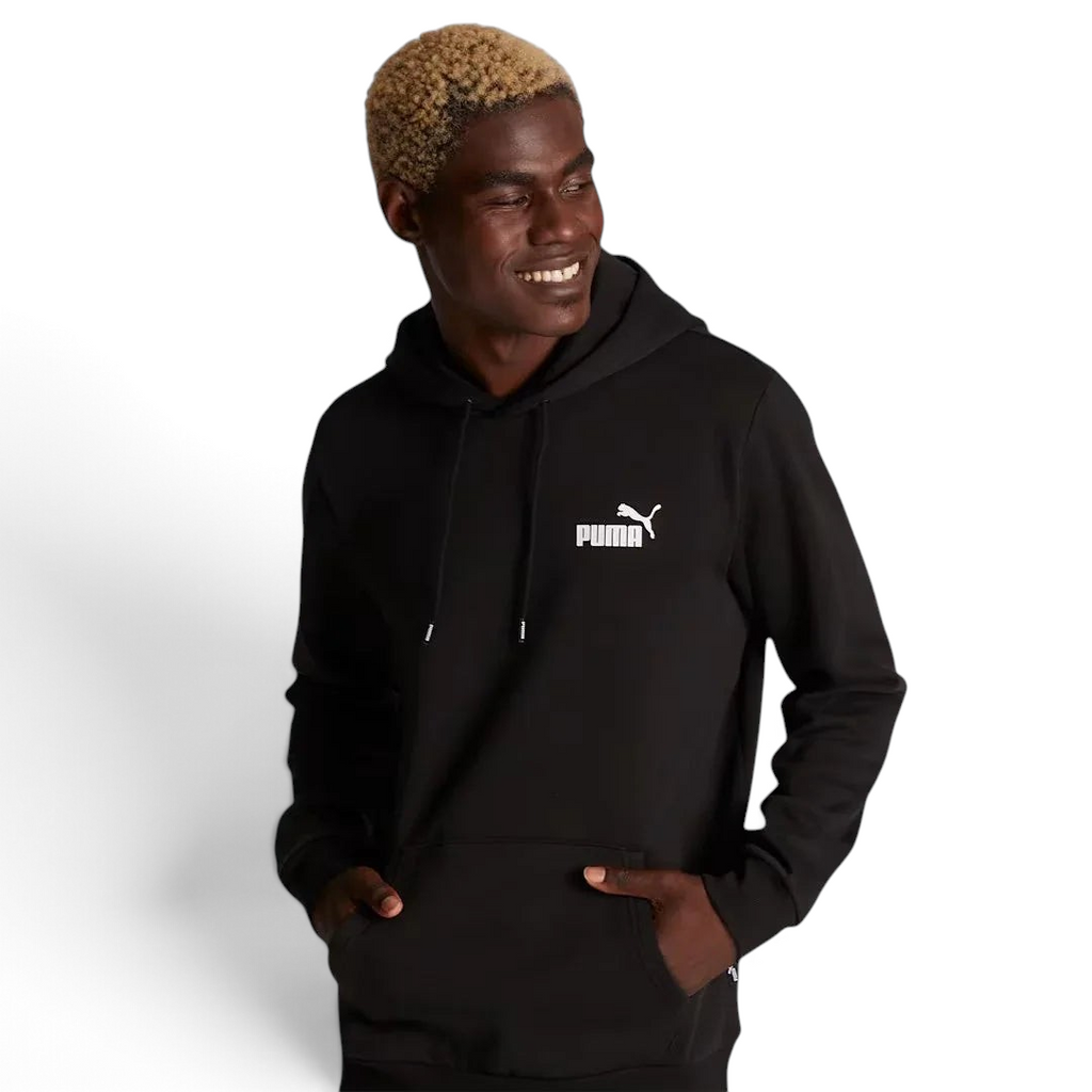 Puma Essential Small Logo Overhead Fleece Hoodie in black, front view worn by a model showing a ribbed hood, a small Puma Cat Logo on the chest, and a kangaroo pocket.