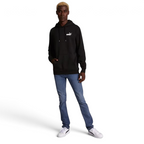 distant model view off the Puma Essential Small Logo Overhead Fleece Hoodie in black, showing the soft fleece fabric texture and the detailed embroidered Puma Cat Logo.