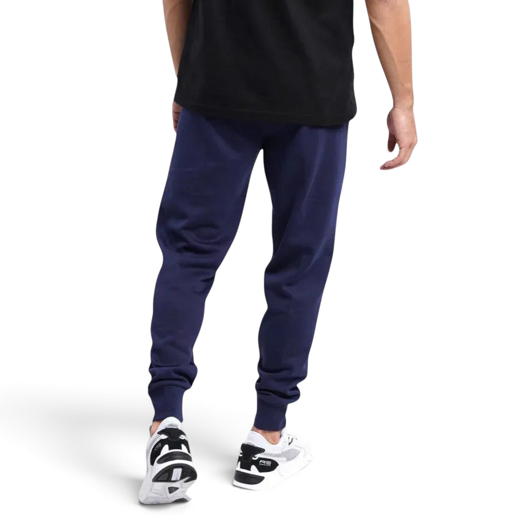 Puma Essential Logo Pants Men's in navy fleece, back view worn by a model showcasing the tapered leg design and ribbed cuffs.