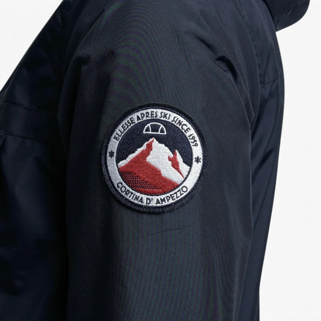 Close-up zoom on the fabric of the Ellesse Mont 2 Overhead Anorak Jacket, showing the textured finish and the embroidered or printed Ellesse logo.