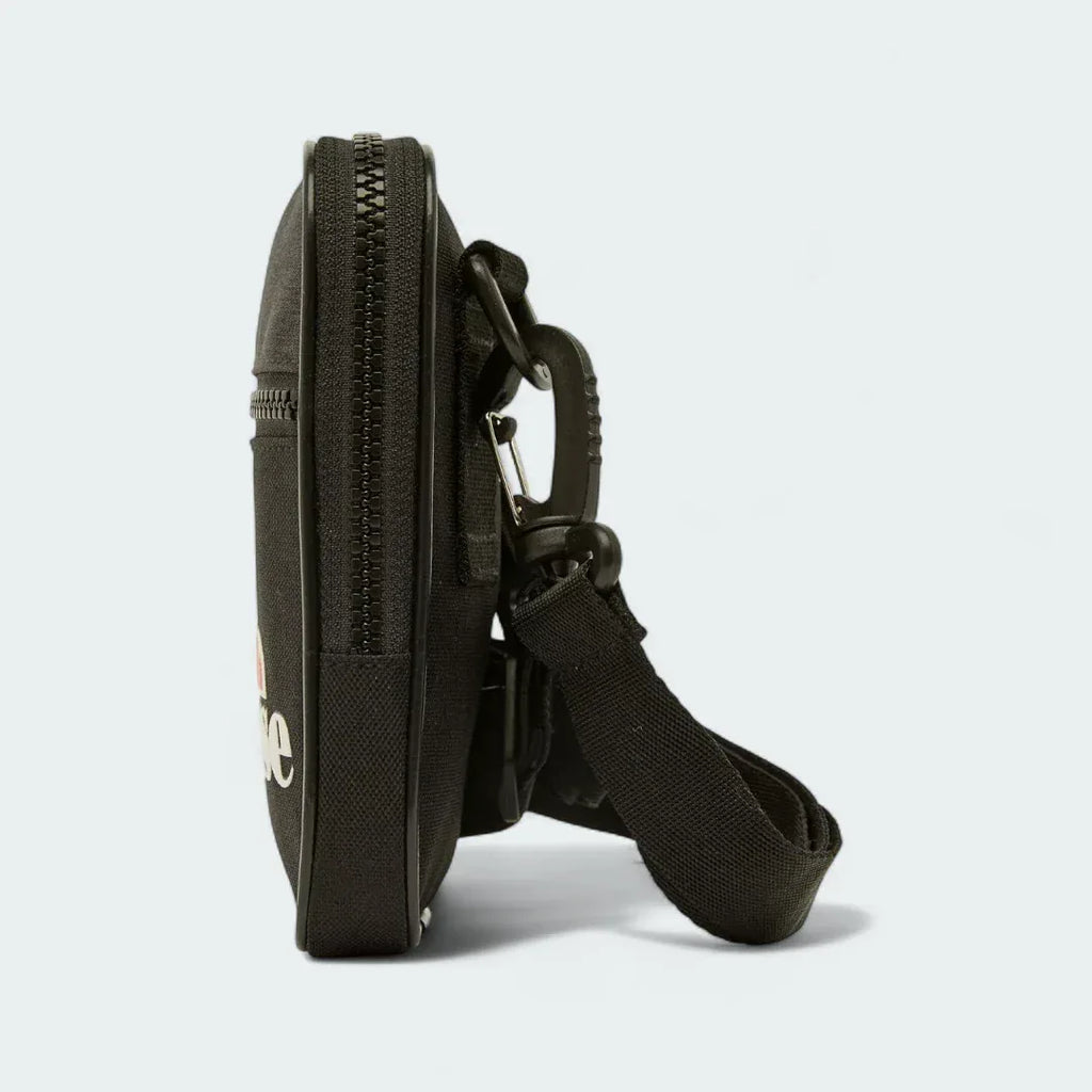 Ellesse Templeton Crossbody Bag in black, side profile showing its compact depth and the strap attachment points.