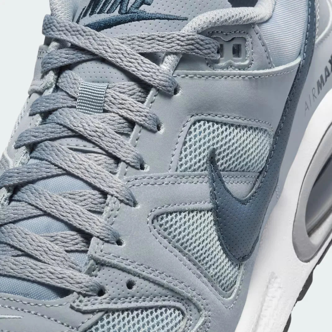 Close-up zoom on the front of the Nike Air Max Command Men's grey trainers, showing the perforated toe box, lacing system, and textured upper.