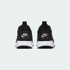 Rear view of the Nike Air Max Tavas Men's black trainers, focusing on the visible Max Air unit in the heel and subtle branding.