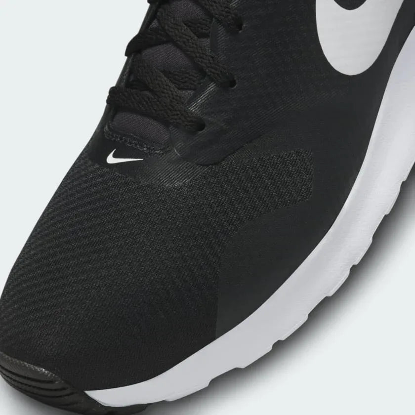 Close-up zoom on the front of the Nike Air Max Tavas Men's black trainers, showing the mesh toe box, lacing system, and seamless overlays.