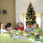 Children playing with toys at a table in front of a Christmas tree.