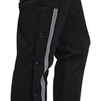 Close-up zoom on the Adidas 7/8 Cropped Snap Pants Women's in black, showing the individual snap buttons along the side and the texture of the knit fabric.