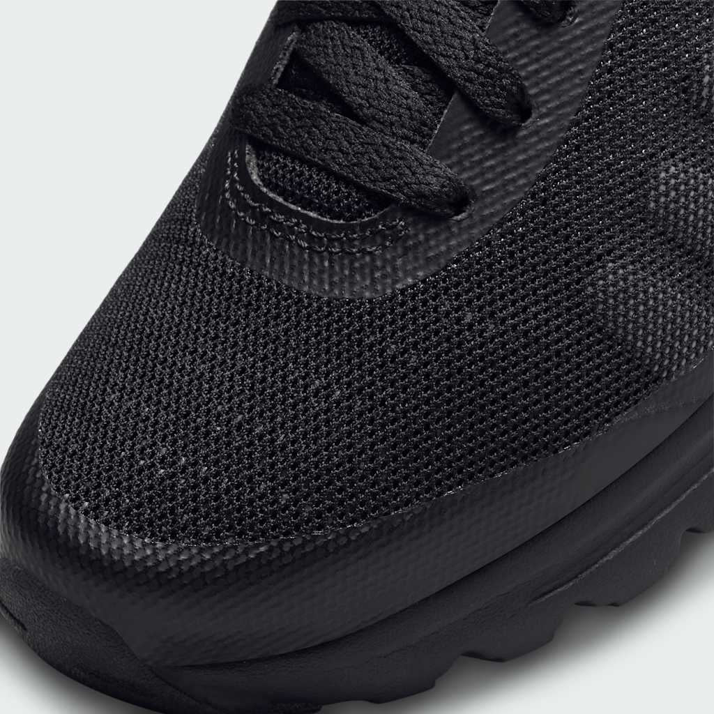 Close-up of Nike Air Max Invigor Juniors Trainers Black 749572-003 laces, tongue logo, and mesh texture