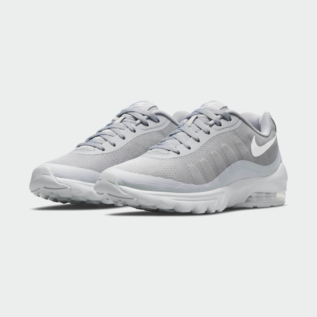 Angled view of two Nike Air Max Invigor Men's grey trainers, side by side, showcasing their modern aesthetic and lightweight construction.