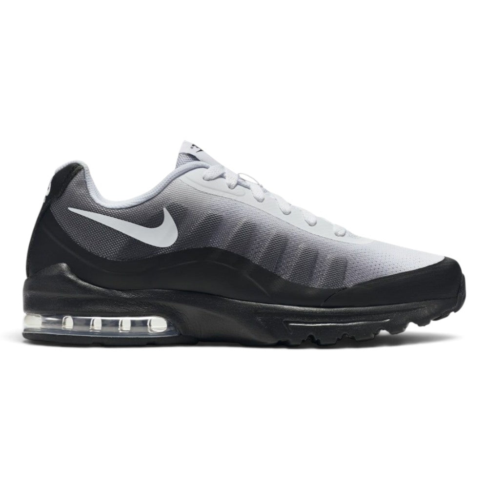 Capturing the streamlined road running silhouette, detailing the midnight navy engineered knit upper, white lateral Swoosh logo, external visible Achilles heel puffs, sculpted white foam midsole carrier, and dark rubber outsole profile.