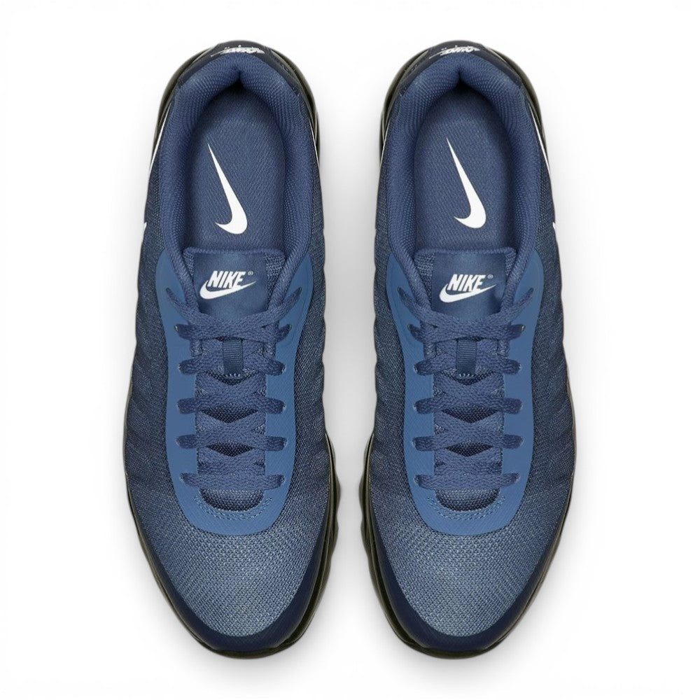 Overhead view of both sneakers showing the Breathe Tech mesh forefeet, central lacing systems, and navy blue insoles printed with white Nike branding.