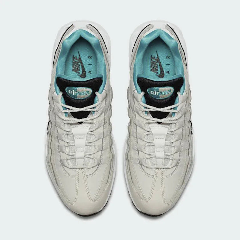 Top-down view of a pair of Nike Air Max 95 Essential Men's running shoes in beige, highlighting their iconic silhouette and lacing system.
