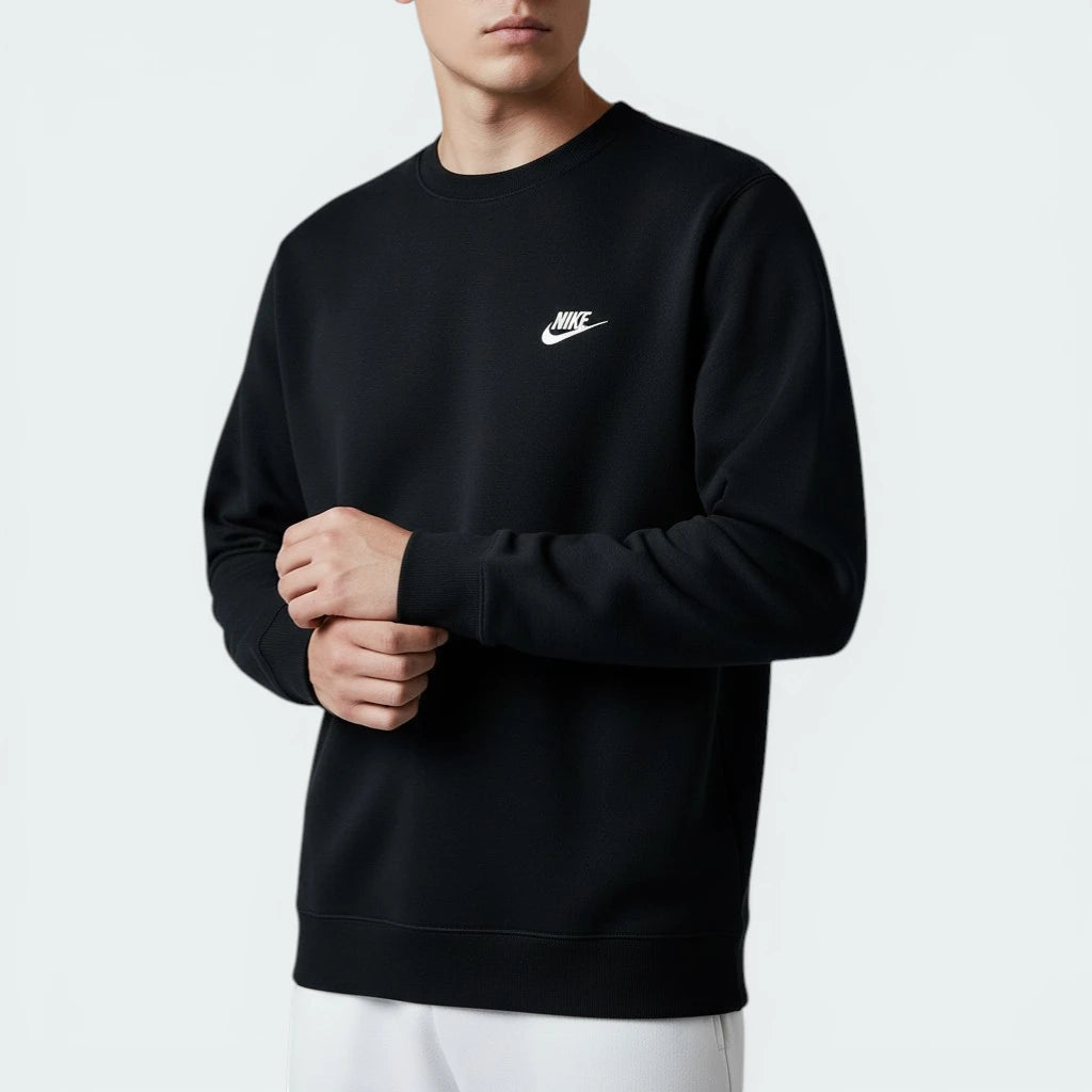 Person wearing a black Nike sweatshirt on a light gray background