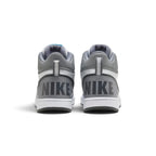 Rear-angle studio shot focusing on the grey heel wrap featuring bold block-letter "NIKE" branding and vertical heel pull tabs.