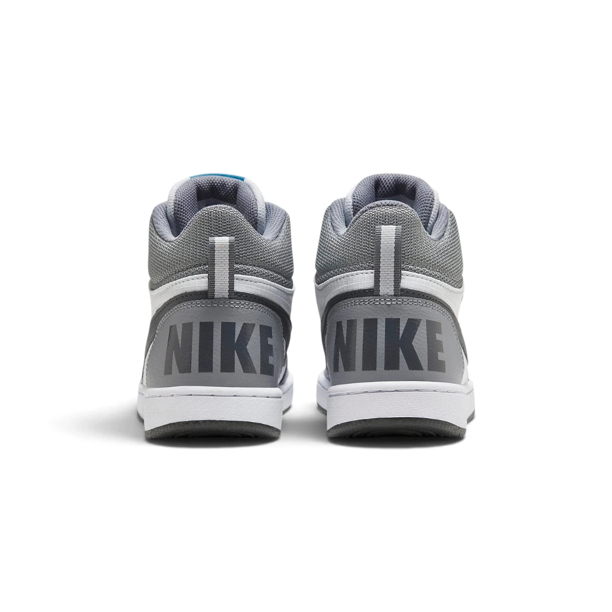 Rear-angle studio shot focusing on the grey heel wrap featuring bold block-letter "NIKE" branding and vertical heel pull tabs.