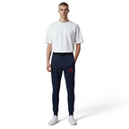 Person wearing navy jogger pants with a red logo and a white t-shirt on a white background