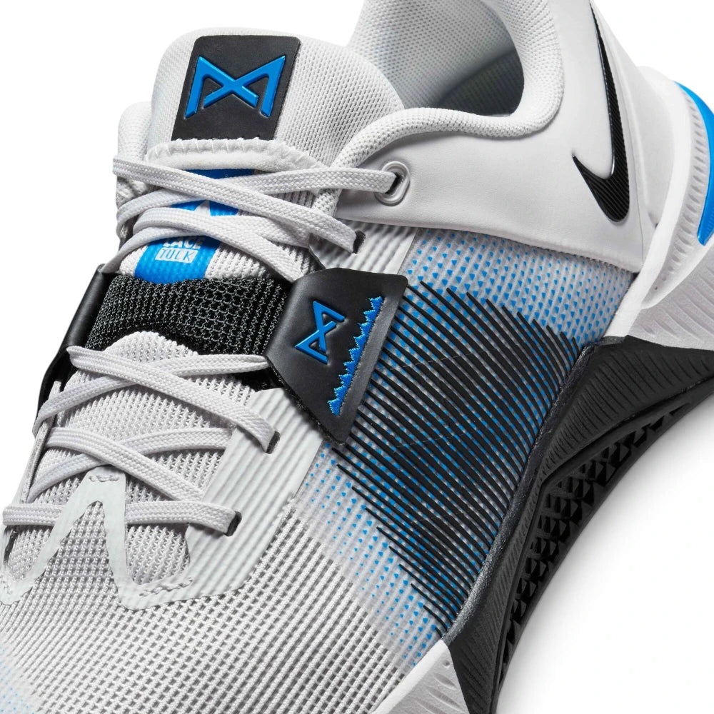 Close-up view of the forefoot and lacing system, displaying the light grey mesh texture, integrated laces, black textured midfoot overlay, and the black lace-lock tab with a blue Metcon logo and blue "Lace Tuck" tongue tab.