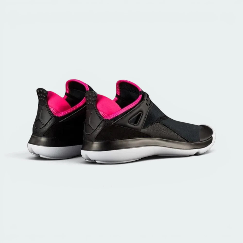 Focuses on the contoured shape of the extended AJ4 heel tab, showcasing the high-definition speckling covering the pull loop.
