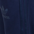 Close-up of a navy blue Adidas tracksuit with logo and zipper detail.