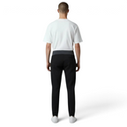Person wearing a white t-shirt and black pants on a white background