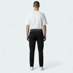 Person wearing a white t-shirt and black pants on a white background