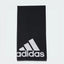 Focuses on the full front profile of the neatly folded towel, highlighting the crisp, high-contrast white adidas Badge of Sport logo block printed squarely against the rich black terry loop background.