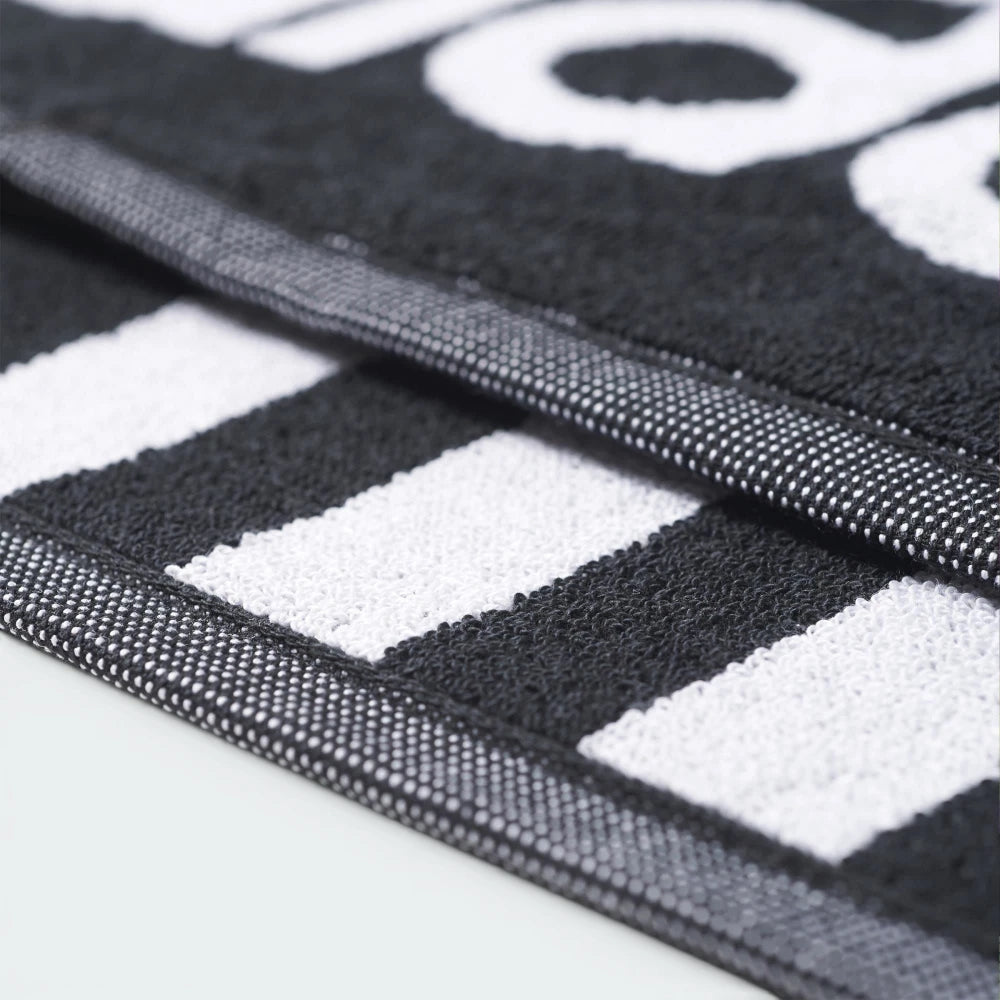 Highlights a macro view of the edge structure, displaying the tight double-needle stitching of the finished border running smoothly alongside the prominent white stripes.