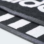 Highlights a macro view of the edge structure, displaying the tight double-needle stitching of the finished border running smoothly alongside the prominent white stripes.