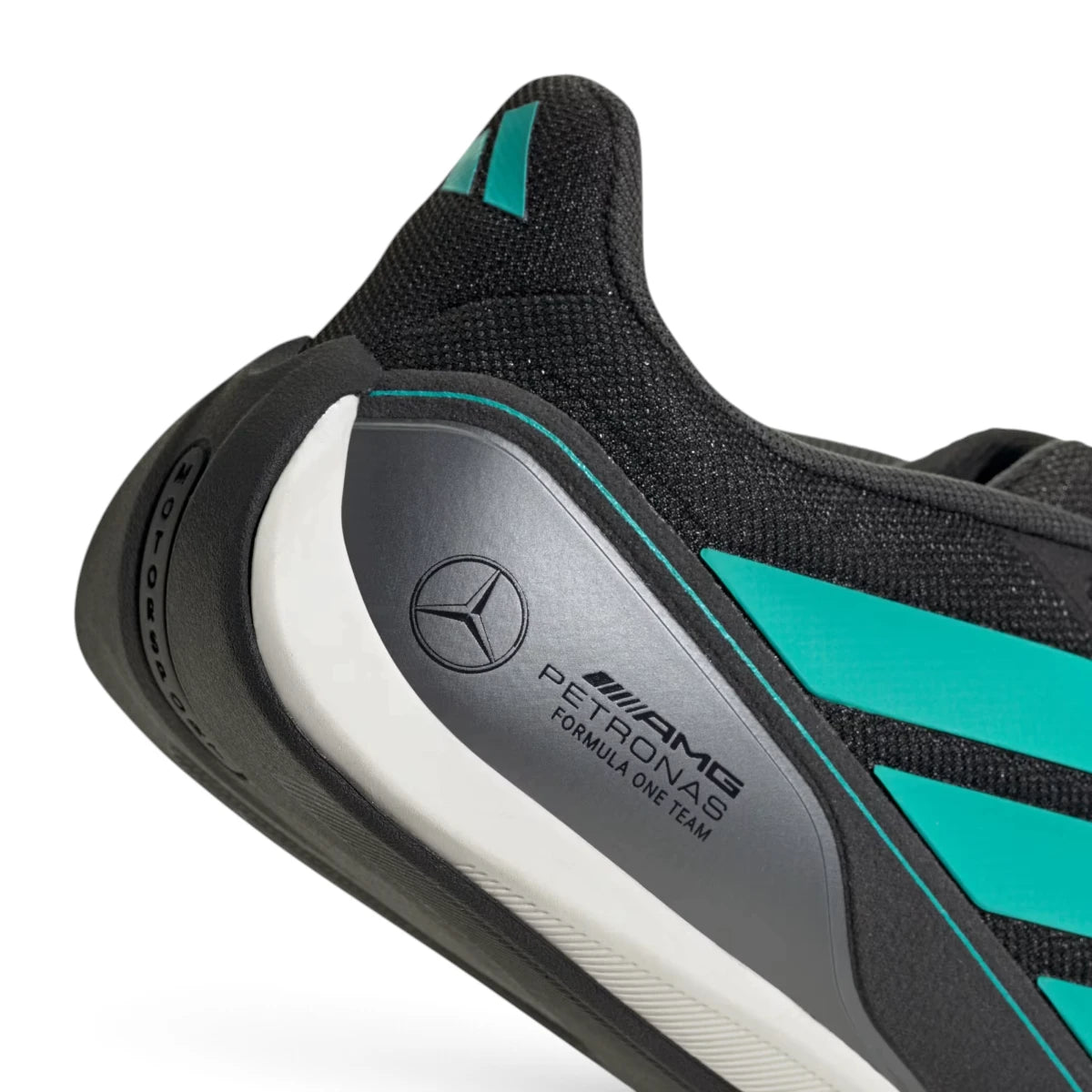 Macro focus on the metallic heel counter featuring the official team typography and the iconic Mercedes three-pointed star emblem.