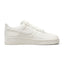 Displays the full lateral silhouette featuring the soft Pink Oxford mesh upper, the striking layered metallic Swoosh design, the thick white React foam midsole with embedded Air Zoom branding, and the textured outsole edge