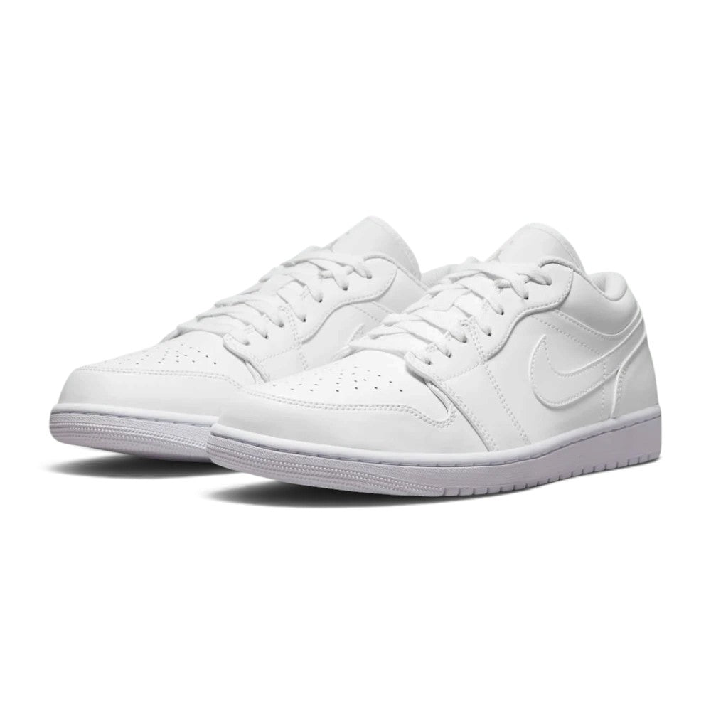 Three-quarter forward angle of the Air Jordan 1 Low trainers, showcasing their classic 1985 basketball aesthetic and clean monochromatic color-blocking.